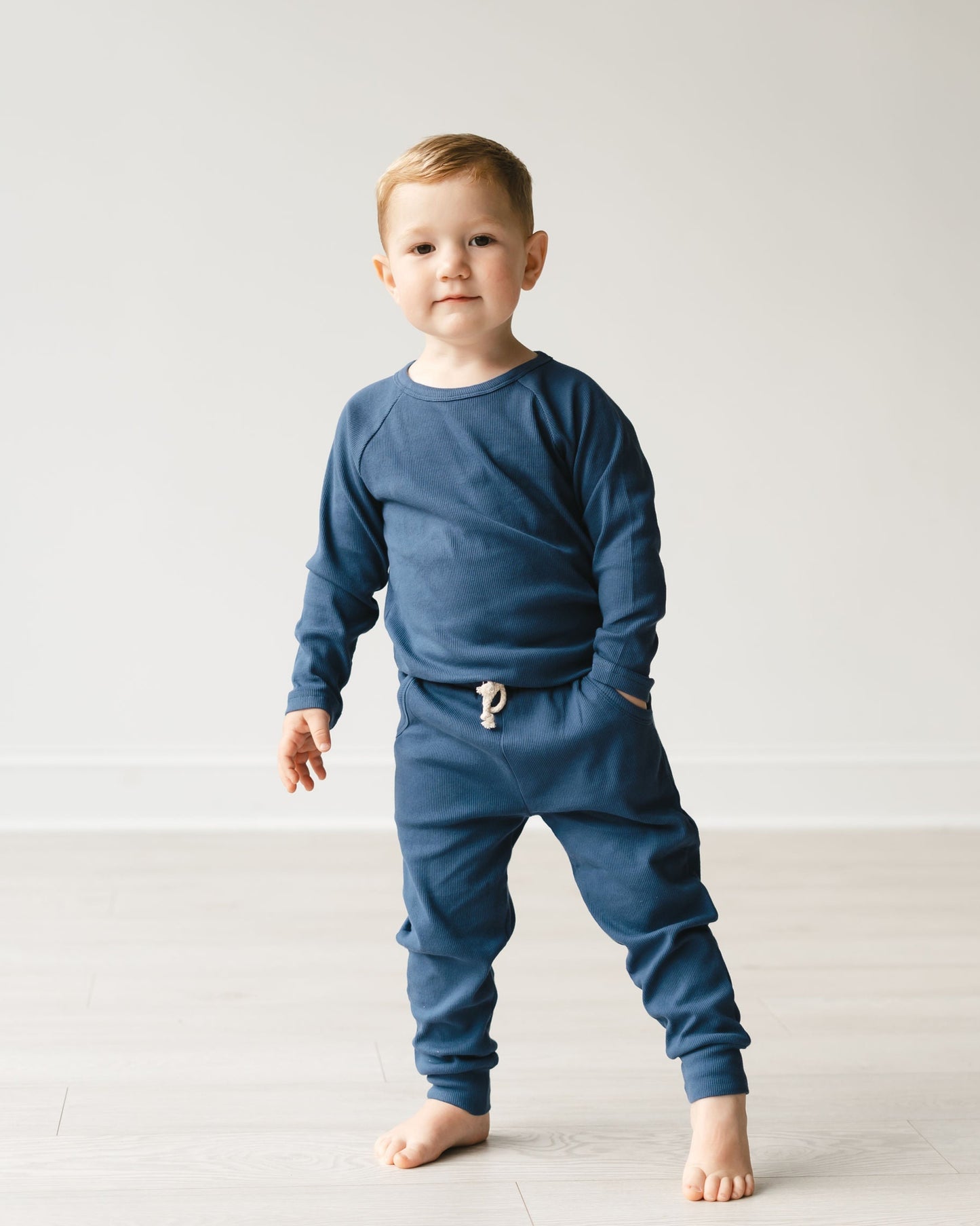 Child wearing a blue outfit with a white background