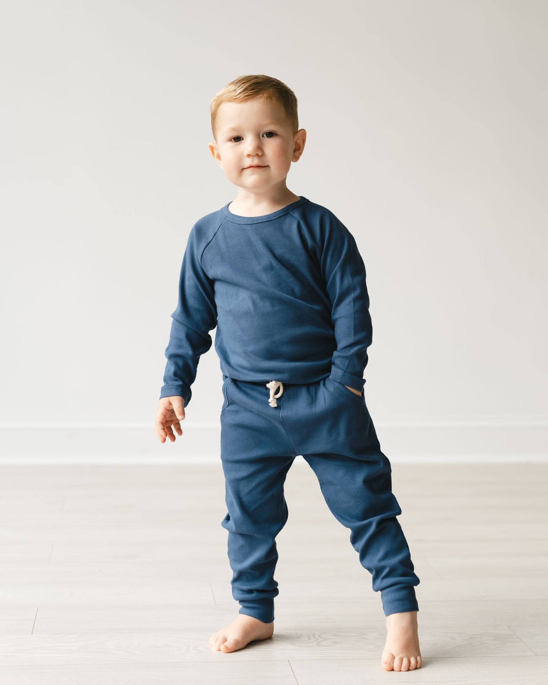 Child wearing a blue outfit with a white background